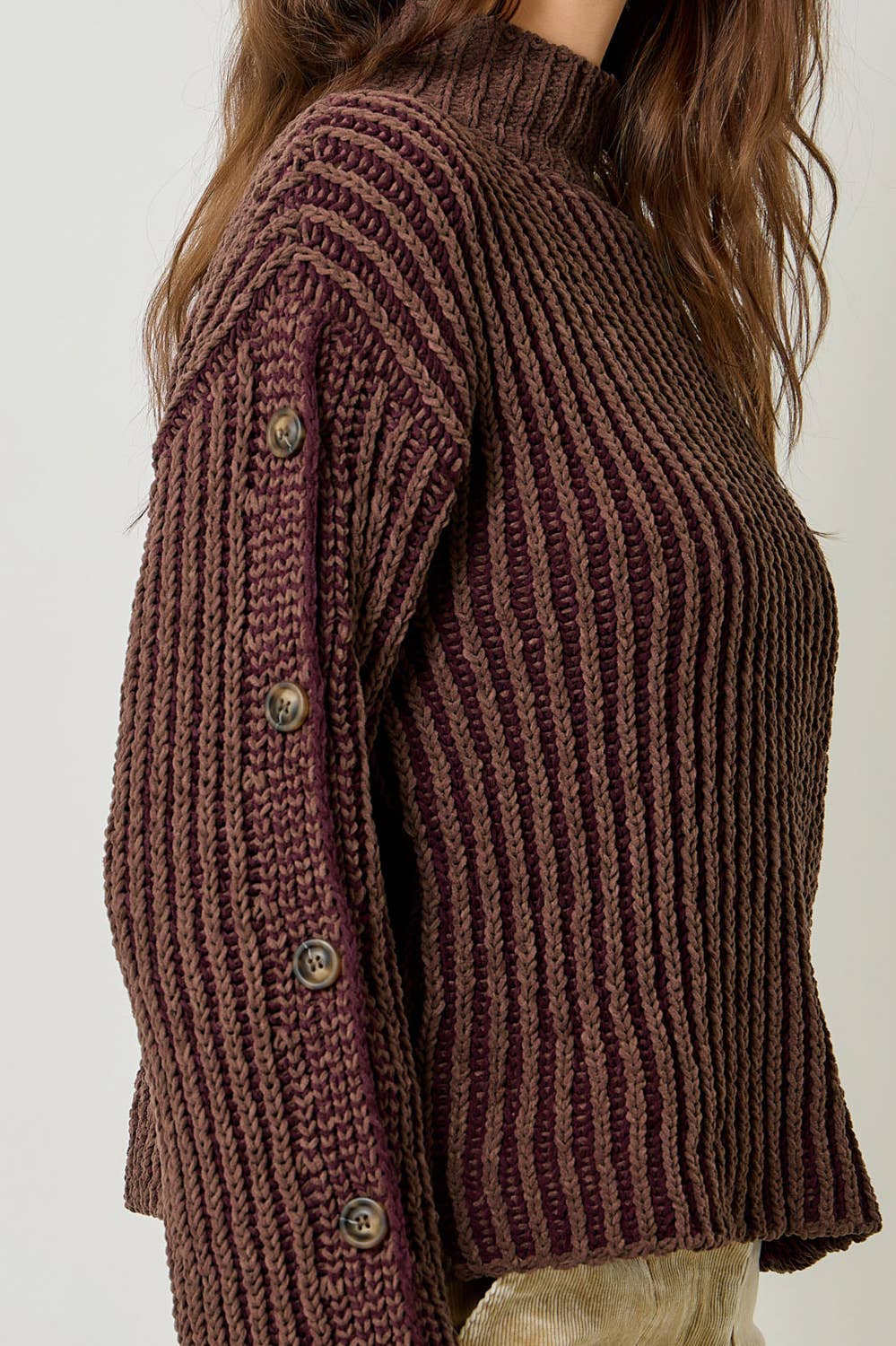 A stylish velvet sweater with color-blocking and decorative buttons.