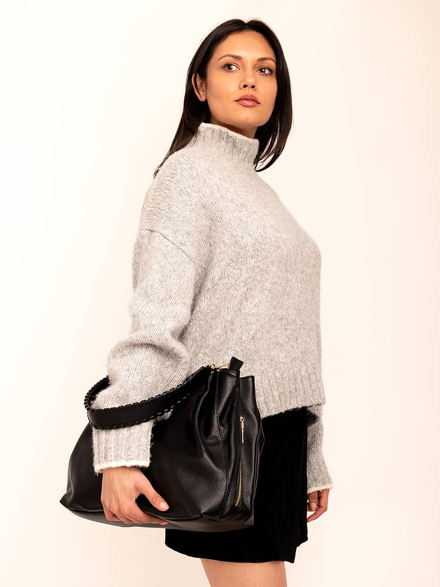Multi-compartment leather tote with handcrafted details and top handle.