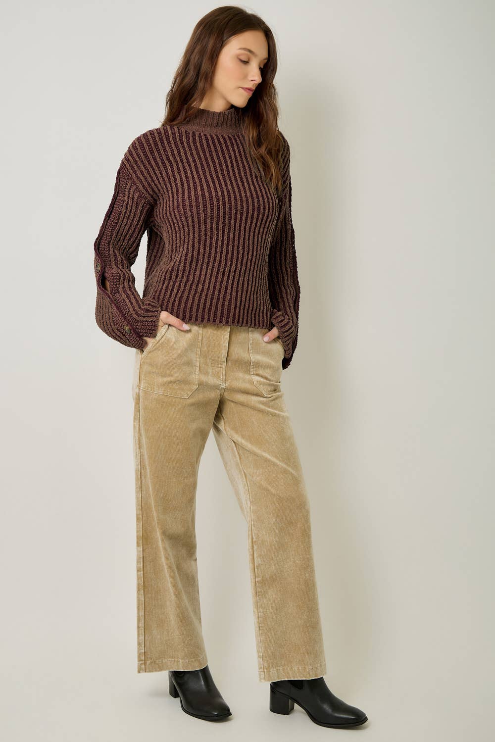 A stylish velvet sweater with color-blocking and decorative buttons.