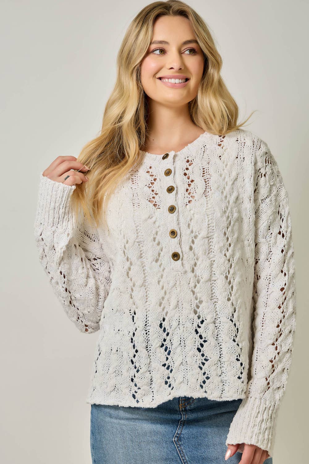 Soft velvet knit top for women with decorative buttons and ribbed cuffs.