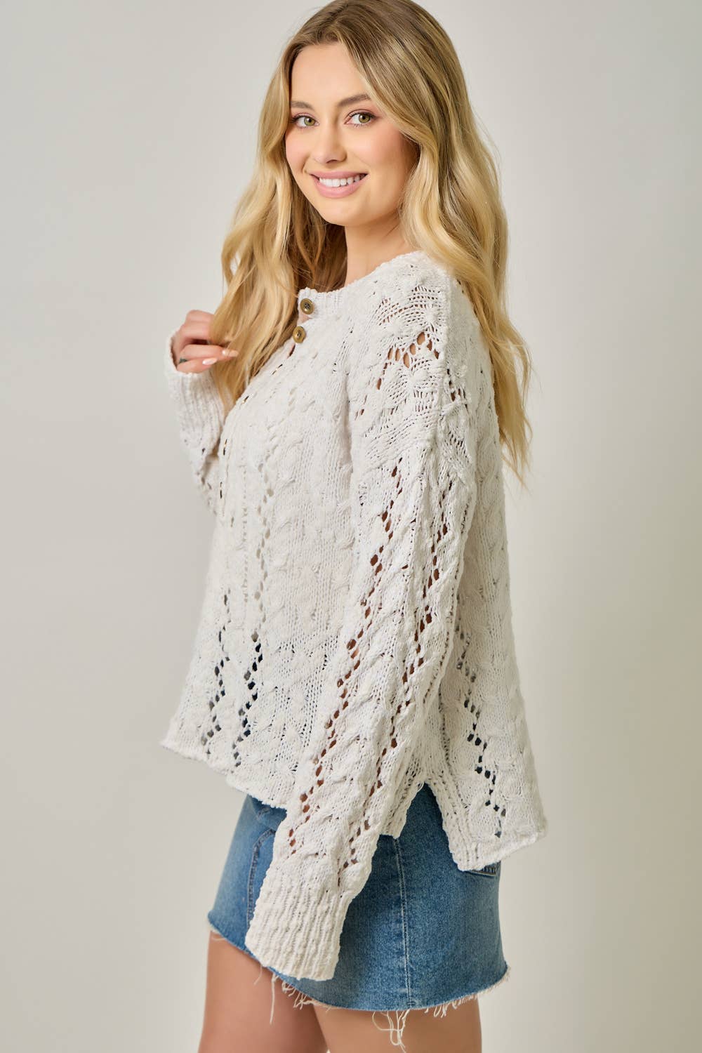 Soft velvet knit top for women with decorative buttons and ribbed cuffs.