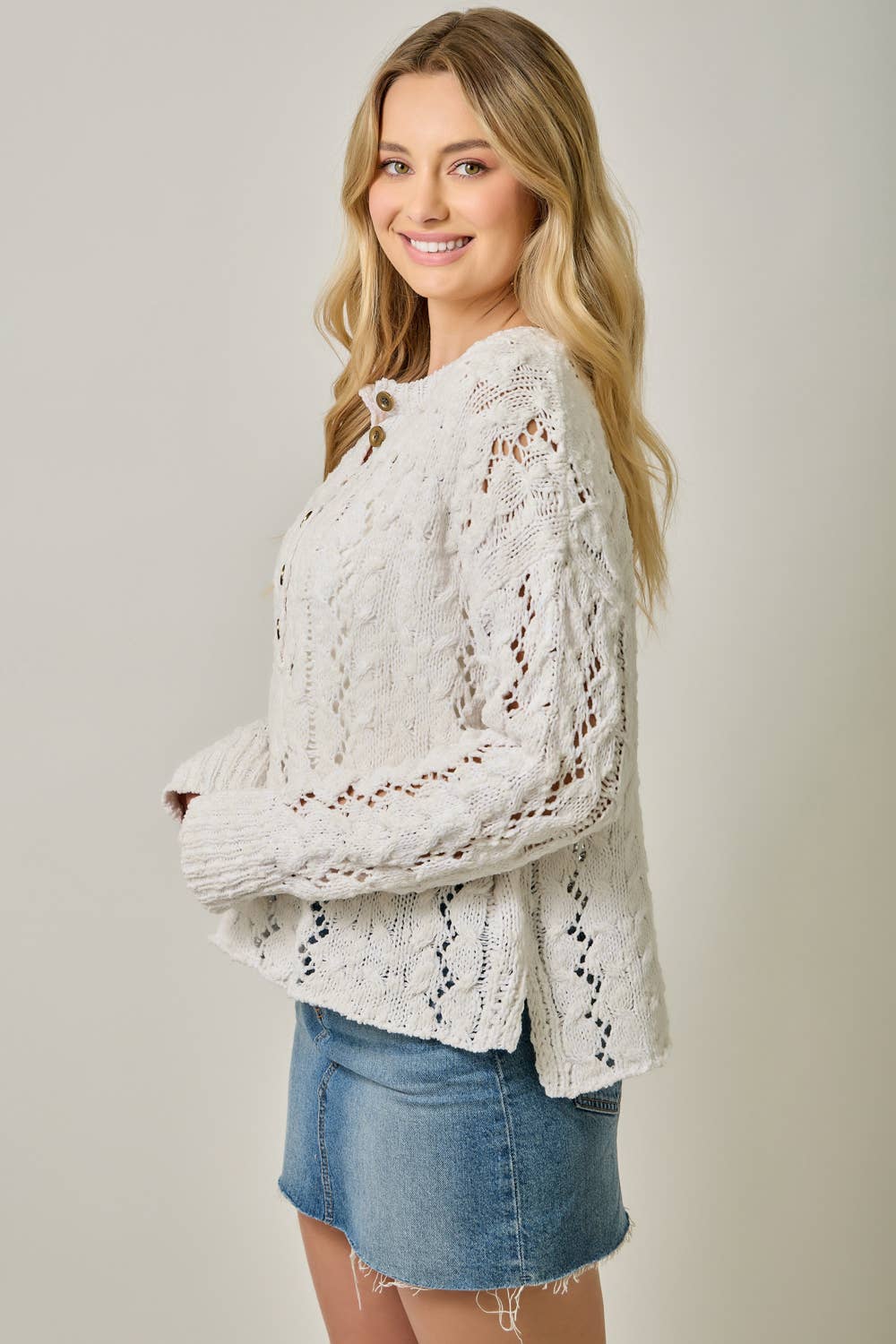 Soft velvet knit top for women with decorative buttons and ribbed cuffs.