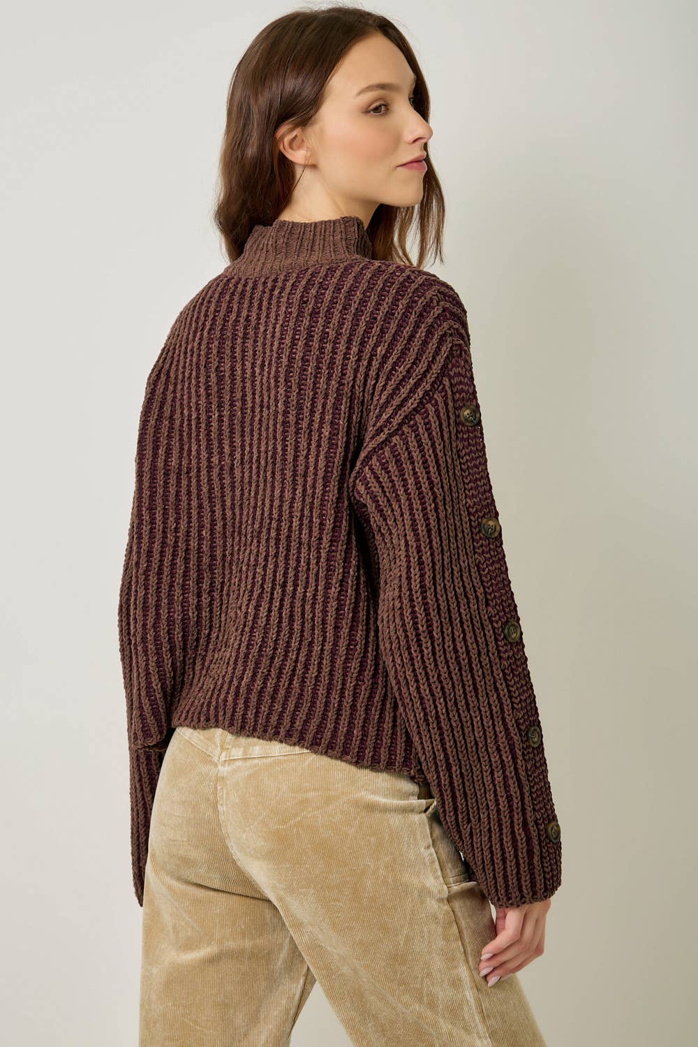 A stylish velvet sweater with color-blocking and decorative buttons.