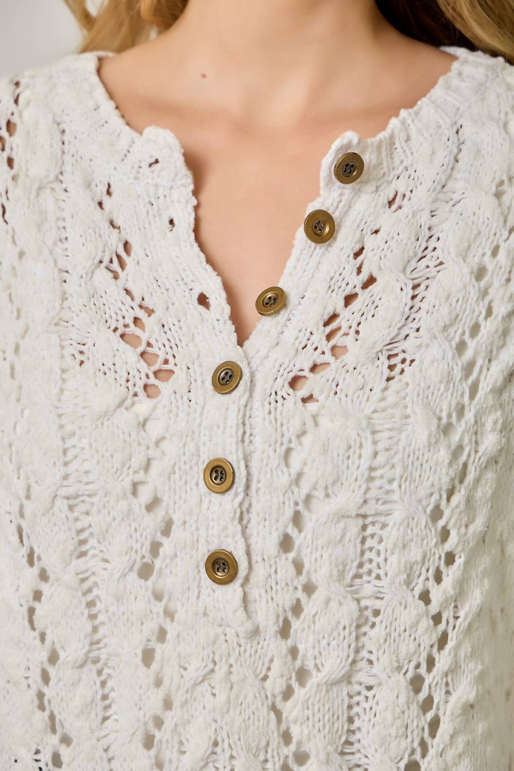 Soft velvet knit top for women with decorative buttons and ribbed cuffs.