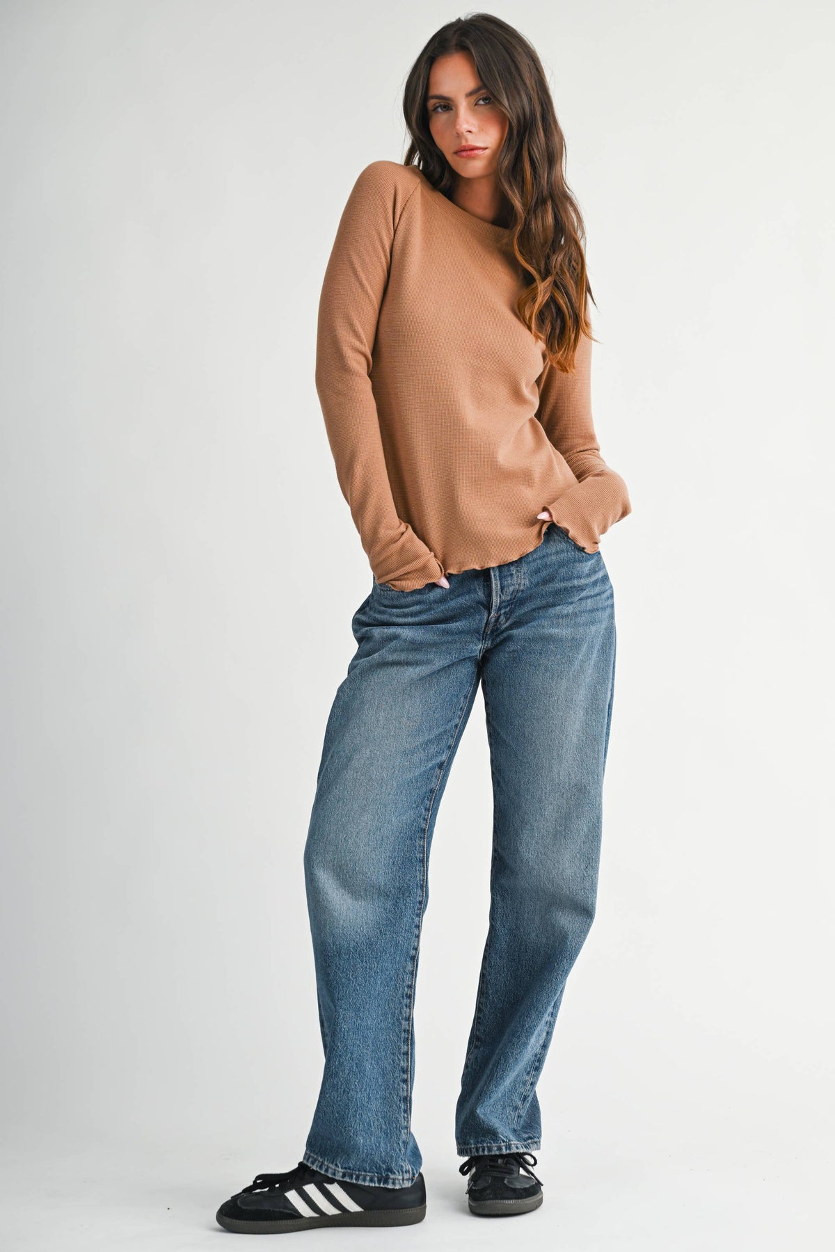 A soft, stylish top featuring a ribbed neckline and lettuce edge detailing.