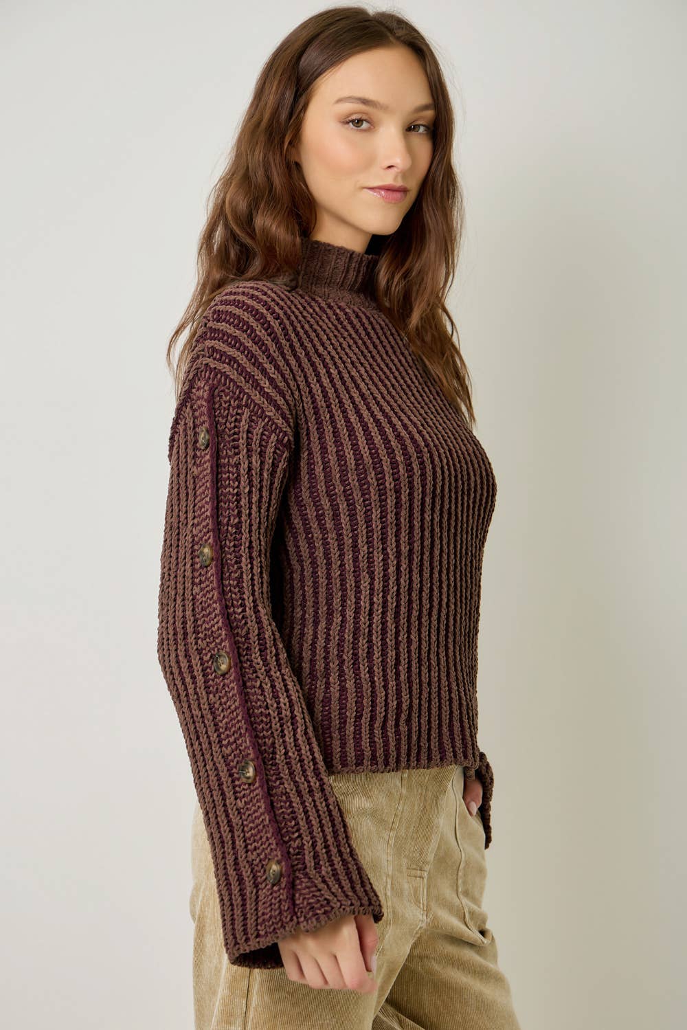 A stylish velvet sweater with color-blocking and decorative buttons.