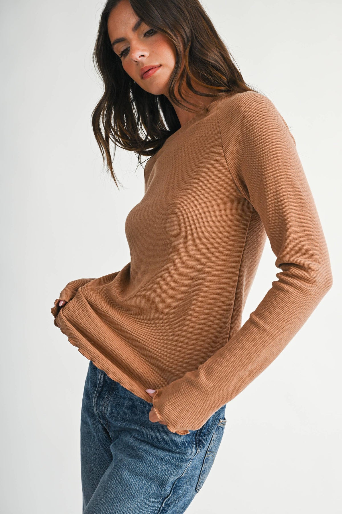 A soft, stylish top featuring a ribbed neckline and lettuce edge detailing.