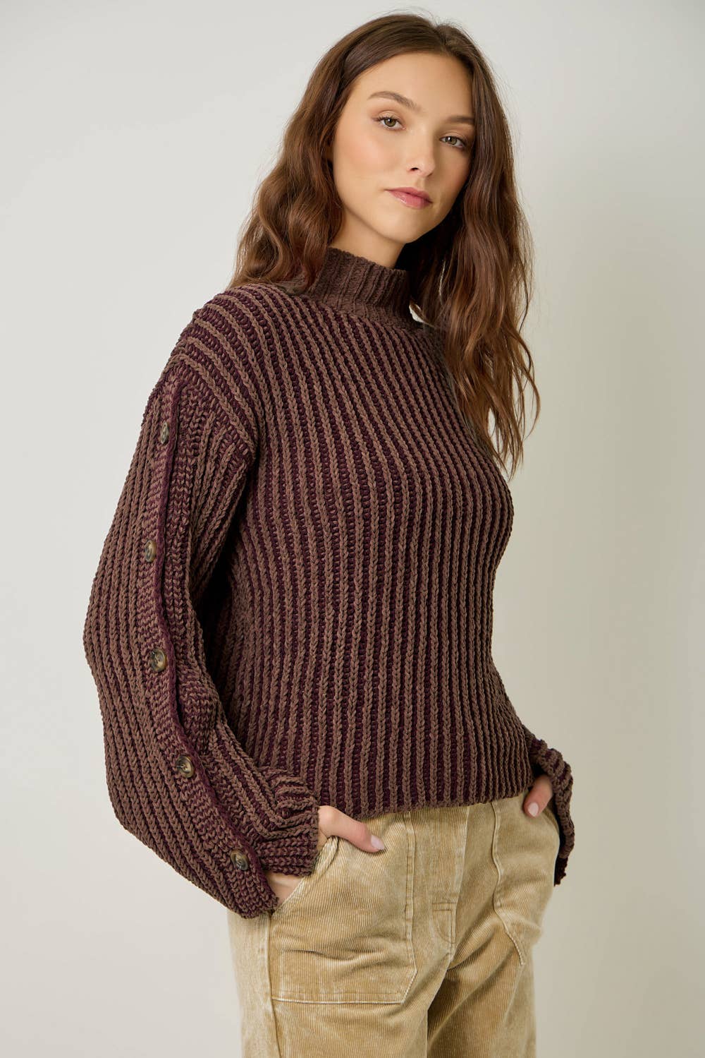 A stylish velvet sweater with color-blocking and decorative buttons.