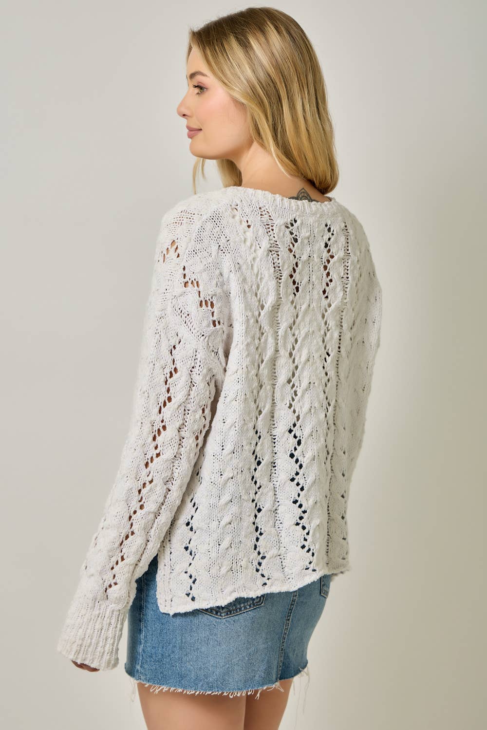 Soft velvet knit top for women with decorative buttons and ribbed cuffs.