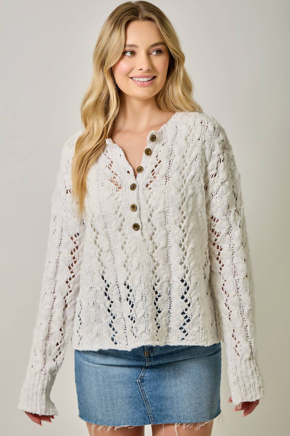 Soft velvet knit top for women with decorative buttons and ribbed cuffs.