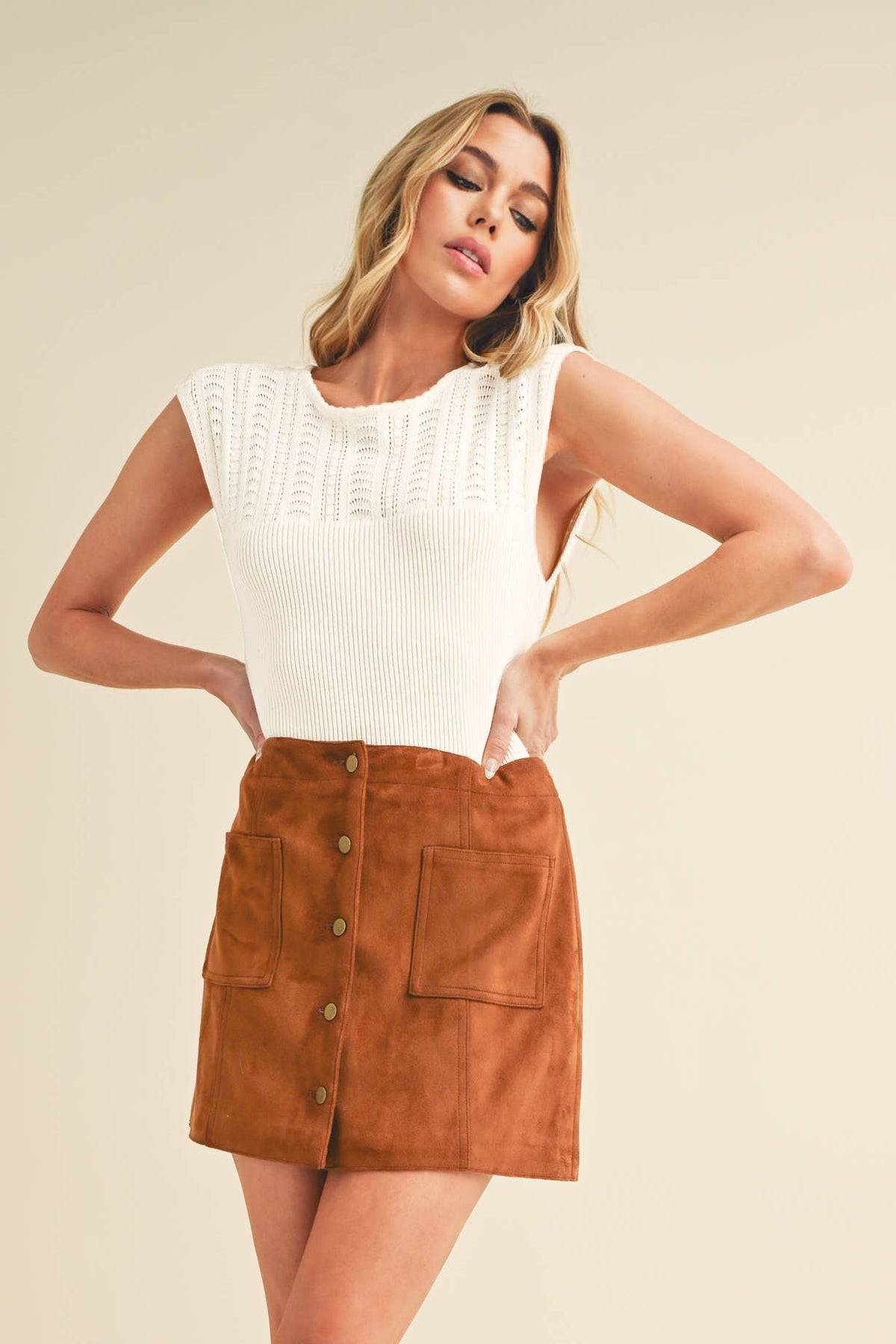 Fitted sleeveless top with ribbed knit and braided design.