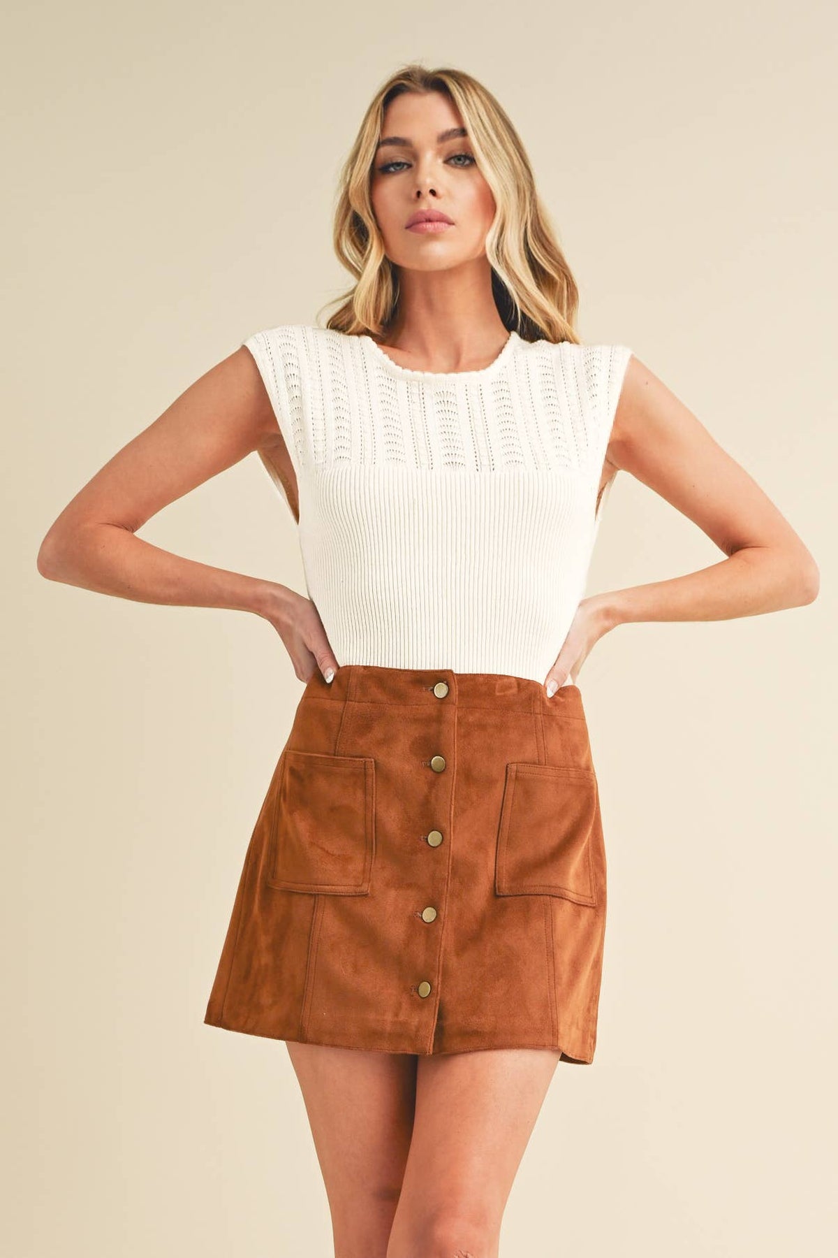 Fitted sleeveless top with ribbed knit and braided design.